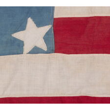 ANTIQUE AMERICAN FLAG WITH 37 STARS ON A CORNFLOWER BLUE CANTON, ARRANGED IN A UNIQUE “GREAT STAR” OR “GREAT LUMINARY” CONFIGURATION, INCORPORATED INTO A RECTANGULAR MEDALLION; A HOMEMADE EXAMPLE, MADE DURING THE ERA OF AMERICAN RECONSTRUCTION; REFLECTS NEBRASKA STATEHOOD, 1867-1876