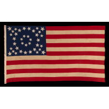 EXCEPTIONAL ANTIQUE AMERICAN FLAG WITH 38 GLAZED COTTON STARS, IN 3 DIFFERENT SIZES, ARRANGED IN A BEAUTIFULLY GRAPHIC, DOUBLE-WREATH STYLE MEDALLION, WITH TRIANGLES OF 4 STARS IN EACH CORNER, LIKELY MADE FOR THE 1876 CENTENNIAL, REFLECTS THE ERA WHEN COLORADO WAS THE MOST RECENT STATE TO JOIN THE UNION, 1876-1889