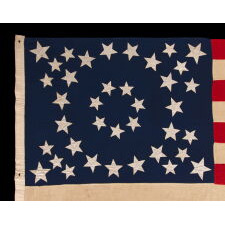 EXCEPTIONAL ANTIQUE AMERICAN FLAG WITH 38 GLAZED COTTON STARS, IN 3 DIFFERENT SIZES, ARRANGED IN A BEAUTIFULLY GRAPHIC, DOUBLE-WREATH STYLE MEDALLION, WITH TRIANGLES OF 4 STARS IN EACH CORNER, LIKELY MADE FOR THE 1876 CENTENNIAL, REFLECTS THE ERA WHEN COLORADO WAS THE MOST RECENT STATE TO JOIN THE UNION, 1876-1889