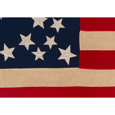 EXCEPTIONAL ANTIQUE AMERICAN FLAG WITH 38 GLAZED COTTON STARS, IN 3 DIFFERENT SIZES, ARRANGED IN A BEAUTIFULLY GRAPHIC, DOUBLE-WREATH STYLE MEDALLION, WITH TRIANGLES OF 4 STARS IN EACH CORNER, LIKELY MADE FOR THE 1876 CENTENNIAL, REFLECTS THE ERA WHEN COLORADO WAS THE MOST RECENT STATE TO JOIN THE UNION, 1876-1889