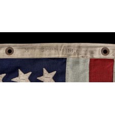 ANTIQUE AMERICAN FLAG WITH 48 STARS, A U.S. NAVY SMALL BOAT ENSIGN, MADE IN SEPTEMBER OF 1943, DURING WWII, AT MARE ISLAND, CALIFORNIA, HEADQUARTERS OF THE PACIFIC FLEET, WITH ENDEARING WEAR FROM OBVIOUS LONG-TERM USE