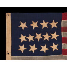 ANTIQUE AMERICAN FLAG WITH A WHIMSICAL PRESENTATION OF 13 STARS IN THE 4-5-4 PATTERN, A VERY EARLY EXAMPLE, MADE circa 1835-1850’s, BOLDY GRAPHIC, ENTIRELY HAND-SEWN AND IN A TINY SCALE AMONG ITS COUNTERPARTS, PROBABLY A U.S. NAVY SMALL BOAT ENSIGN