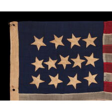 ANTIQUE AMERICAN FLAG WITH A WHIMSICAL PRESENTATION OF 13 STARS IN THE 4-5-4 PATTERN, A VERY EARLY EXAMPLE, MADE circa 1835-1850’s, BOLDY GRAPHIC, ENTIRELY HAND-SEWN AND IN A TINY SCALE AMONG ITS COUNTERPARTS, PROBABLY A U.S. NAVY SMALL BOAT ENSIGN