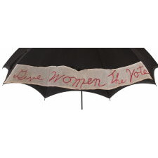 BLACK, TASSELLED, EDWARDIAN STYLE PARASOL / UMBRELLA, MADE BY FOLLMER, CLOGG & Co. OF LANCASTER, PENNSYLVANIA, MODIFIED FOR SUFFRAGETTE USE BY WAY OF AN APPLIED, CHIFFON SILK PANEL WITH FANCIFUL, SCRIPT-EMBROIDERY THAT READS: “GIVE WOMEN THE VOTE,” circa 1900-1915