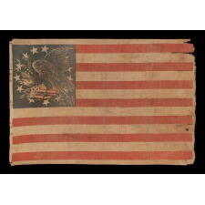 EXTRAORDINARILY RARE ANTIQUE AMERICAN FLAG WITH A THREE-COLOR CANTON THAT CONSISTS OF A TREMENDOUS, WARLIKE EAGLE, PERCHED ON A FEDERAL SHIELD, SET WITHIN A RING OF 14 STARS; MADE IN THE PERIOD BETWEEN THE MEXICAN AND CIVIL WARS (1846 – 1865) THIS IS THE ONLY KNOWN EXAMPLE IN THIS STYLE AND THE LARGEST OF ALL KNOWN RECORDED PARADE FLAGS WITH AN EAGLE AS THE PRIMARY IMAGE