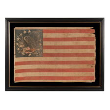 EXTRAORDINARILY RARE ANTIQUE AMERICAN FLAG WITH A THREE-COLOR CANTON THAT CONSISTS OF A TREMENDOUS, WARLIKE EAGLE, PERCHED ON A FEDERAL SHIELD, SET WITHIN A RING OF 14 STARS; MADE IN THE PERIOD BETWEEN THE MEXICAN AND CIVIL WARS (1846 – 1865) THIS IS THE ONLY KNOWN EXAMPLE IN THIS STYLE AND THE LARGEST OF ALL KNOWN RECORDED PARADE FLAGS WITH AN EAGLE AS THE PRIMARY IMAGE