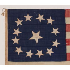 13 STAR ANTIQUE AMERICAN FLAG WITH A CIRCULAR VERSION OF WHAT IS KNOWN AS THE 3RD MARYLAND PATTERN, ENTIRELY HAND-SEWN, WITH ESPECIALLY LARGE STARS SURROUNDING AN EVEN LARGER CENTER STAR; MADE SOMETIME BETWEEN 1850 AND THE CIVIL WAR (1861-65), AN EXCEPTIONAL EXAMPLE WITH WONDERFUL FOLK QUALITIES