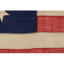 13 STAR ANTIQUE AMERICAN FLAG WITH A CIRCULAR VERSION OF WHAT IS KNOWN AS THE 3RD MARYLAND PATTERN, ENTIRELY HAND-SEWN, WITH ESPECIALLY LARGE STARS SURROUNDING AN EVEN LARGER CENTER STAR; MADE SOMETIME BETWEEN 1850 AND THE CIVIL WAR (1861-65), AN EXCEPTIONAL EXAMPLE WITH WONDERFUL FOLK QUALITIES