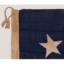 13 STAR ANTIQUE AMERICAN FLAG WITH A CIRCULAR VERSION OF WHAT IS KNOWN AS THE 3RD MARYLAND PATTERN, ENTIRELY HAND-SEWN, WITH ESPECIALLY LARGE STARS SURROUNDING AN EVEN LARGER CENTER STAR; MADE SOMETIME BETWEEN 1850 AND THE CIVIL WAR (1861-65), AN EXCEPTIONAL EXAMPLE WITH WONDERFUL FOLK QUALITIES