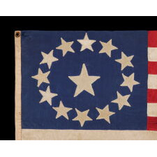 13 STAR ANTIQUE AMERICAN FLAG, MADE OF FINE SILK, WITH AN OVAL VERSION OF WHAT IS KNOWN AS THE 3RD MARYLAND PATTERN AND A LARGE CENTER STAR, IN AN EXTRAORDINARILY TINY SIZE AMONG FLAGS WITH SEWN CONSTRUCTION; FOUND IN WESTERN MASSACHUSETTS, MADE SOMETIME BETWEEN THE 1850’s AND THE CIVIL WAR (1861-65), LIKELY FOR A MILITIA OR VOLUNTEER UNIT, OR AN OFFICER THEREOF; ILLUSTRATED IN “THE STARS & THE STRIPES: FABRIC OF THE AMERICAN SPIRIT” BY RICHARD PIERCE, 2005