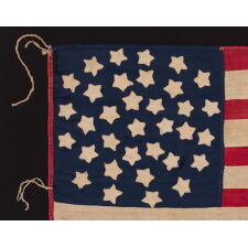 34 STAR ANTIQUE AMERICAN FLAG OF THE CIVIL WAR PERIOD (1861-63), IN A TINY SCALE AMONG PIECED-AND-SEWN FLAGS OF THE PERIOD, WITH A TRIPLE-WREATH CONFIGURATION, AN ELONGATED FORMAT, AND ENTIRELY HAND-SEWN; FOUND WITH A LETTER FROM JOHN W. RUDE OF THE 2ND KENTUCKY VETERAN VOLUNTEER CAVALRY (UNION)