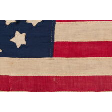 34 STAR ANTIQUE AMERICAN FLAG OF THE CIVIL WAR PERIOD (1861-63), IN A TINY SCALE AMONG PIECED-AND-SEWN FLAGS OF THE PERIOD, WITH A TRIPLE-WREATH CONFIGURATION, AN ELONGATED FORMAT, AND ENTIRELY HAND-SEWN; FOUND WITH A LETTER FROM JOHN W. RUDE OF THE 2ND KENTUCKY VETERAN VOLUNTEER CAVALRY (UNION)