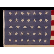 34 STAR MERINO WOOL FLAG OF THE CIVIL WAR PERIOD, WITH ITS STARS ORIENTED IN VARIOUS DIRECTIONS ON A PERIWINKLE BLUE CANTON; HIGHLY UNUSUAL; REFLECTS THE ADDITION OF KANSAS TO THE UNION AS A FREE STATE, circa 1861-1863