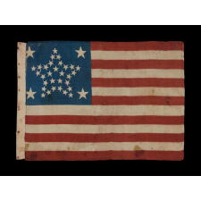 34 STARS IN A RARE “GREAT STAR” PATTERN THAT INCORPORATES HUGE CORNER STARS, ON AN ANTIQUE AMERICAN PARADE FLAG MADE DURING THE OPENING TWO YEARS OF THE CIVIL WAR, circa 1861-63; REFLECTS KANSAS STATEHOOD