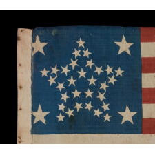 34 STARS IN A RARE “GREAT STAR” PATTERN THAT INCORPORATES HUGE CORNER STARS, ON AN ANTIQUE AMERICAN PARADE FLAG MADE DURING THE OPENING TWO YEARS OF THE CIVIL WAR, circa 1861-63; REFLECTS KANSAS STATEHOOD
