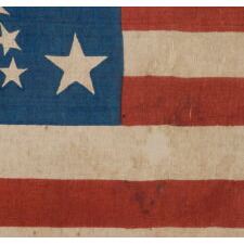 34 STARS IN A RARE “GREAT STAR” PATTERN THAT INCORPORATES HUGE CORNER STARS, ON AN ANTIQUE AMERICAN PARADE FLAG MADE DURING THE OPENING TWO YEARS OF THE CIVIL WAR, circa 1861-63; REFLECTS KANSAS STATEHOOD