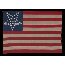 36 STARS IN THE "GREAT STAR" OR "GREAT LUMINARY" PATTERN, ON A MERINO WOOL FLAG OF THE CIVIL WAR ERA WITH BEAUTIFUL SCARLET AND ROYAL BLUE COLOR AND WITH ITS CANTON RESTING ON THE "WAR STRIPE," REFLECTS NEVADA STATEHOOD, 1864-67