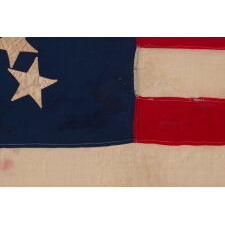ANTIQUE AMERICAN FLAG OF THE CIVIL WAR PERIOD, WITH 13 STARS IN A "PINWHEEL GREAT STAR," A MASTERPIECE OF EARLY AMERICAN FLAG-MAKING