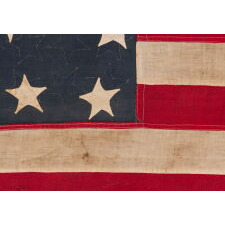 EXTRAORDINARY CIVIL WAR ERA FLAG, WITH 13 HAND-SEWN STARS ARRANGED IN A VARIANT OF WHAT IS KNOWN AS THE TRUMBULL PATTERN, FEATURING A HUGE, UPSIDE-DOWN CENTER STAR, AND THE EXTREMELY RARE TRAIT OF HAVING A DIFFERENT STAR COUNT ON THE REVERSE, WHICH DISPLAYS 36 STARS; HANDED DOWN THROUGH THE FAMILY OF GROVE H. "STOWE" DUDLEY OF THE 100th INDIANA, circa 1864-67