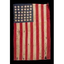 EXTRAORDINARY CIVIL WAR ERA FLAG, WITH 13 HAND-SEWN STARS ARRANGED IN A VARIANT OF WHAT IS KNOWN AS THE TRUMBULL PATTERN, FEATURING A HUGE, UPSIDE-DOWN CENTER STAR, AND THE EXTREMELY RARE TRAIT OF HAVING A DIFFERENT STAR COUNT ON THE REVERSE, WHICH DISPLAYS 36 STARS; HANDED DOWN THROUGH THE FAMILY OF GROVE H. "STOWE" DUDLEY OF THE 100th INDIANA, circa 1864-67