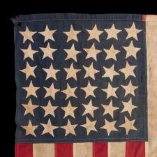 EXTRAORDINARY CIVIL WAR ERA FLAG, WITH 13 HAND-SEWN STARS ARRANGED IN A VARIANT OF WHAT IS KNOWN AS THE TRUMBULL PATTERN, FEATURING A HUGE, UPSIDE-DOWN CENTER STAR, AND THE EXTREMELY RARE TRAIT OF HAVING A DIFFERENT STAR COUNT ON THE REVERSE, WHICH DISPLAYS 36 STARS; HANDED DOWN THROUGH THE FAMILY OF GROVE H. "STOWE" DUDLEY OF THE 100th INDIANA, circa 1864-67