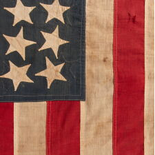 EXTRAORDINARY CIVIL WAR ERA FLAG, WITH 13 HAND-SEWN STARS ARRANGED IN A VARIANT OF WHAT IS KNOWN AS THE TRUMBULL PATTERN, FEATURING A HUGE, UPSIDE-DOWN CENTER STAR, AND THE EXTREMELY RARE TRAIT OF HAVING A DIFFERENT STAR COUNT ON THE REVERSE, WHICH DISPLAYS 36 STARS; HANDED DOWN THROUGH THE FAMILY OF GROVE H. "STOWE" DUDLEY OF THE 100th INDIANA, circa 1864-67