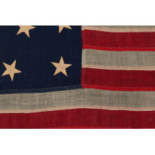 13 STARS IN THE 4-5-4 PATTERN ON AN ENTIRELY HAND-SEWN FLAG OF THE CIVIL WAR PERIOD, OR JUST PRIOR, circa 1854-1864, WITH HEMP ROPE AND A SINGLE TASSEL; PROBABLY A U.S. NAVY SMALL BOAT ENSIGN; SIGNED “JENNIE B. SEAVER,” NEWTON, MASSACHUSETTS
