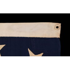 13 STARS IN A CRUDE SINGLE WREATH, REMINISCENT OF THE BETSY ROSS PATTERN, THOUGH RENDERED AS MORE OF AN OVAL; ON AN ANTIQUE AMERICAN FLAG MADE & SIGNED BY THE SHOP OF WILLIAM SCHEIBLE, 49 S. 3RD STREET, PHILADELPHIA, APPROX. TWO BLOCKS FROM INDEPENDENCE HALL AND THE SAME FROM THE BETSY ROSS HOUSE; A CIVIL WAR ERA FLAG, WITH AN EXTREMELY RARE & DESIRABLE CONFIGURATION OF STARS FOR THIS PERIOD, CIRCA 1861-65