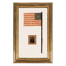29 STARS IN A SPECTACULAR CROSS OR STARBURST MEDALLION, ONE OF JUST TWO KNOWN EXAMPLES IN THIS STYLE, PRE-CIVIL WAR, 1846-48, MEXICAN WAR PERIOD, REFLECTS THE ADDITION OF IOWA AS THE 29TH STATE; FORMERLY AMONG THE POSSESSIONS OF CORPORAL NATHANIEL POWERS, COLOR BEARER IN THE 10TH MASSACHUSETTS VOLUNTEERS, WHO LOST HIS ARM AT THE BATTLE OF FAIR OAKS, VIRGINIA IN 1862; THE FLAG-ITS STAFF WRAPPED IN BLACK CREPE—IS REPORTED TO HAVE BEEN DISTRIBUTED TO MOURNERS IN THE STREETS OF WASHINGTON, DC, ON