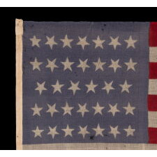 34 STARS WITH "DANCING" OR "TUMBLING" ORIENTATION, ON AN ANTIQUE AMERICAN FLAG, PRESS-DYED ON WOOL BUNTING, WITH A PERIWINKLE BLUE CANTON; LIKELY PRODUCED FOR USE AS MILITARY CAMP COLORS; CIVIL WAR PERIOD, circa 1861-1863, REFLECTS THE ADDITION OF KANSAS TO THE UNION AS A FREE STATE