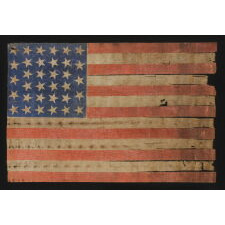 34 STARS ON AN ANTIQUE AMERICAN PARADE FLAG OF THE CIVIL WAR PERIOD, LARGE AMONG ITS COUNTERPARTS, WITH EXTENSIVE AND ENDEARING WEAR FROM OBVIOUS LONG-TERM USE; REFLECTS THE ERA WHEN KANSAS WAS THE MOST RECENT STATE TO JOIN THE UNION, 1861-63