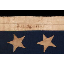 34 UPSIDE-DOWN, HAND-SEWN STARS IN A NOTCHED CONFIGURATION, ON AN ANTIQUE AMERICAN FLAG OF THE CIVIL WAR PERIOD, WITH A BEAUTIFUL AND HIGHLY UNUSUAL JACQUARD WEAVE BINDING, AND IN A TINY SCALE AMONG ITS COUNTERPARTS, REFLECTS THE ADDITION OF KANSAS AS THE 34TH STATE, 1861-1863