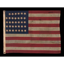 34 UPSIDE-DOWN, HAND-SEWN STARS IN A NOTCHED CONFIGURATION, ON AN ANTIQUE AMERICAN FLAG OF THE CIVIL WAR PERIOD, WITH A BEAUTIFUL AND HIGHLY UNUSUAL JACQUARD WEAVE BINDING, AND IN A TINY SCALE AMONG ITS COUNTERPARTS, REFLECTS THE ADDITION OF KANSAS AS THE 34TH STATE, 1861-1863