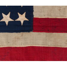 34 UPSIDE-DOWN, HAND-SEWN STARS IN A NOTCHED CONFIGURATION, ON AN ANTIQUE AMERICAN FLAG OF THE CIVIL WAR PERIOD, WITH A SQUARISH PROFILE AND IN AN EXTREMELY SMALL SCALE AMONG ITS COUNTERPARTS; FOUND IN PENNSYLVANIA & RELATED TO ANOTHER FLAG FOUND IN THE RAFTERS OF A BARN IN PERRY COUNTY; REFLECTS THE ADDITION OF KANSAS AS THE 34TH STATE, circa 1861-1863