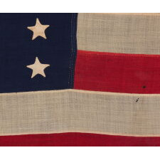 37 STARS IN A VERY RARE DIAMOND CONFIGURATION, WITH PILLARS OF STARS ON EITHER SIDE, NEARLY IDENTICAL TO A LARGER EXAMPLE PRESENTED BY CIVIL WAR GENERAL BENJAMIN BUTLER TO PRESIDENT LINCOLN AS THE FIRST AMERICAN FLAG EVER CONSTRUCTED OF ENTIRELY AMERICAN-MADE MATERIALS, JUST 3 DAYS PRIOR TO HIS 1865 ASSASSINATION; THIS STAR COUNT ANTICIPATORY TO THE FUTURE ADDITION OF NEBRASKA