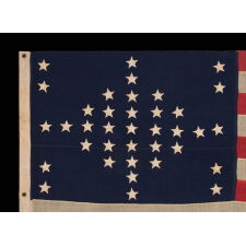 37 STARS IN A VERY RARE DIAMOND CONFIGURATION, WITH PILLARS OF STARS ON EITHER SIDE, NEARLY IDENTICAL TO A LARGER EXAMPLE PRESENTED BY CIVIL WAR GENERAL BENJAMIN BUTLER TO PRESIDENT LINCOLN AS THE FIRST AMERICAN FLAG EVER CONSTRUCTED OF ENTIRELY AMERICAN-MADE MATERIALS, JUST 3 DAYS PRIOR TO HIS 1865 ASSASSINATION; THIS STAR COUNT ANTICIPATORY TO THE FUTURE ADDITION OF NEBRASKA