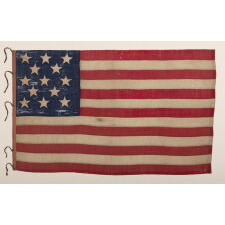 ENTIRELY HAND-SEWN ANTIQUE AMERICAN FLAG OF THE CIVIL WAR ERA, WITH 13 SINGLE-APPLIQUÉD STARS IN A 3-2-3-2-3 CONFIGURATION, IN A GREAT, SMALL SCALE AMONG ITS COUNTERPARTS, PROBABLY MADE IN NEW YORK CITY, SIGNED “GRÜNFILD”