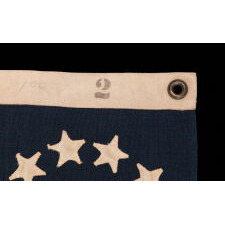 13 HAND-SEWN STARS IN A CIRCULAR VERSION OF WHAT IS KNOWN AS THE “3rd MARYLAND PATTERN,” ON AN ANTIQUE AMERICAN FLAG MADE circa 1876-1895, WITH A HUGE CENTER STAR, AND IN AN INCREDIBLE, TINY SCALE AMONG SEWN FLAGS OF THE 19th CENTURY & PRIOR; AN EXCEPTIONAL ADDITION TO ANY COLLECTION
