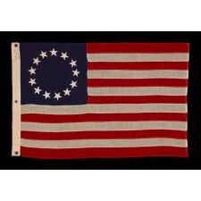 13 STARS IN THE BETSY ROSS PATTERN ON A SMALL-SCALE ANTIQUE AMERICAN FLAG MADE SOMETIME BETWEEN APPROXIMATELY 1910 AND THE 1926 SESQUICENTENNIAL OF AMERICAN INDEPENDENCE