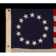 13 STARS IN THE BETSY ROSS PATTERN ON A SMALL-SCALE ANTIQUE AMERICAN FLAG MADE SOMETIME BETWEEN APPROXIMATELY 1910 AND THE 1926 SESQUICENTENNIAL OF AMERICAN INDEPENDENCE