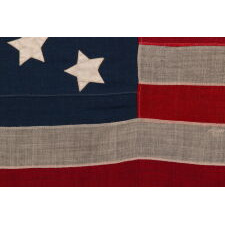 13 STARS IN A MEDALLION CONFIGURATION, ON A SMALL-SCALE ANTIQUE AMERICA FLAG MADE DURING THE LAST DECADE OF THE 19th CENTURY