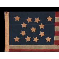13 STARS WITH SHORT, CONICAL ARMS ON A SMALL SCALE, ANTIQUE AMERICAN FLAG WITH A BEAUTIFULLY ELONGATED FORMAT AND MUCH PATINA FROM OBVIOUS USE; MADE DURING THE LAST DECADE OF THE 19th CENTURY, POSSIBLY BY J.S. OBERHOLTZER IN GERMANTOWN [PHILADELPHIA], PENNSYLVANIA