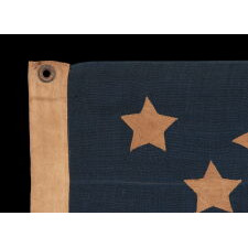 13 STARS WITH SHORT, CONICAL ARMS ON A SMALL SCALE, ANTIQUE AMERICAN FLAG WITH A BEAUTIFULLY ELONGATED FORMAT AND MUCH PATINA FROM OBVIOUS USE; MADE DURING THE LAST DECADE OF THE 19th CENTURY, POSSIBLY BY J.S. OBERHOLTZER IN GERMANTOWN [PHILADELPHIA], PENNSYLVANIA