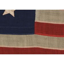 15 STARS IN AN EXTRAORDINARY ARRANGEMENT THAT CONSISTS OF AN OVAL WREATH OF 11, SURROUNDING A SQUARE OF 4; A UNIQUE & ENTIRELY HAND-SEWN, ANTIQUE AMERICAN FLAG MADE WITH SOUTHERN SYMPATHIES, REMOVING THE FREE STATES FROM THE STAR COUNT, LIKELY circa 1861: