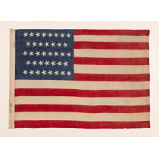 38 CANTED STARS IN STAGGERED ROWS, ON A CLAMP-DYED, WOOL, ANTIQUE AMERICAN FLAG MADE BY THE HORSTMANN BROTHERS IN PHILADELPHIA, ALMOST CERTAINLY FOR DISPLAY AT THE 1876 CENTENNIAL EXPOSITION; A VERY RARE EXAMPLE WITH STRONG COLORS AND GREAT TEXTURE; REFLECTS COLORADO STATEHOOD