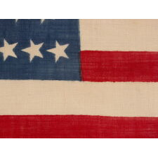 38 CANTED STARS IN STAGGERED ROWS, ON A CLAMP-DYED, WOOL, ANTIQUE AMERICAN FLAG MADE BY THE HORSTMANN BROTHERS IN PHILADELPHIA, ALMOST CERTAINLY FOR DISPLAY AT THE 1876 CENTENNIAL EXPOSITION; A VERY RARE EXAMPLE WITH STRONG COLORS AND GREAT TEXTURE; REFLECTS COLORADO STATEHOOD
