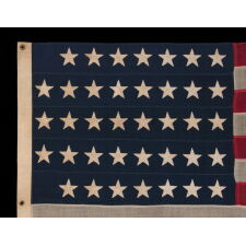 38 HAND-SEWN STARS IN A "NOTCHED" PATTERN, ON AN ANTIQUE AMERICAN FLAG WITH BEAUTIFUL WEAR FROM HAVING BEEN EXTENSIVELY FLOWN, MADE AT THE TIME WHEN COLORADO WAS THE MOST RECENT STATE TO JOIN THE UNION, 1876-1889