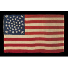 38 STARS, COLORADO STATEHOOD, A SCARCE AND BEAUTIFUL ANTIQUE AMERICAN FLAG WITH A MEDALLION PATTERN AND 4 LARGE CORNER STARS, PRESS-DYED ON WOOL BUNTING, MADE BY HORSTMANN BROTHERS IN PHILADELPHIA FOR THE 1876 CENTENNIAL OF OUR NATION’S INDEPENDENCE