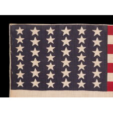 39 STARS IN TWO SIZES, ALTERNATING FROM ONE COLUMN TO THE NEXT, ON AN ANTIQUE AMERICAN PARADE FLAG WITH AN UNUSUALLY ELONGATED PROFILE, DATING TO THE 1876 CENTENNIAL, NEVER AN OFFICIAL STAR COUNT, REFLECTS THE ANTICIPATED ARRIVAL OF COLORADO AND THE DAKOTA
