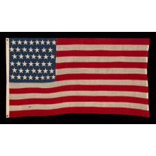 44 STARS IN ZIGZAGGING, STAGGERED ROWS, ON ANTIQUE AMERICAN FLAG WITH SOMEWHAT ELONGATED PROPORTIONS AND STRONG COLORS, MADE IN THE ERA WHEN WYOMING WAS THE MOST RECENT STATE TO JOIN THE UNION, 1890-1896